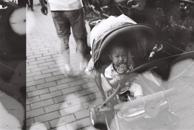 student artwork by Joey Zheng entitled deja-vu. a black-and-white photograph of a boy in a stroller